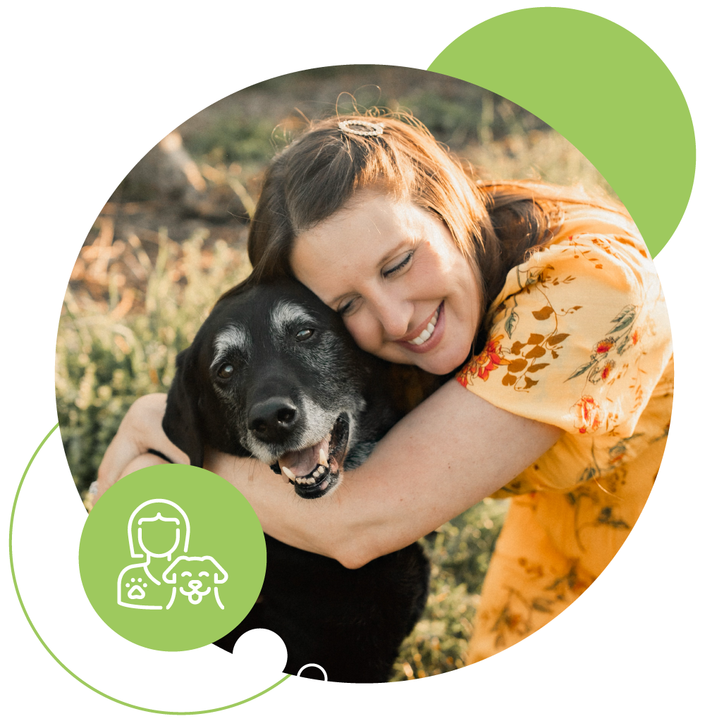 Dr. Christa Corbett in a yellow dress hugging her large black dog.